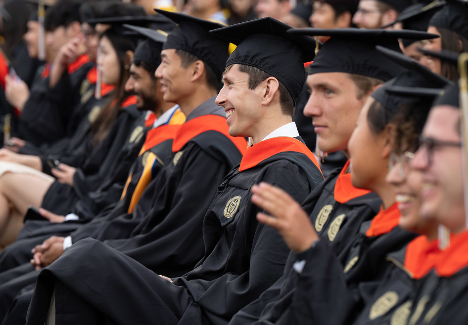 smiling graduates seated in a row